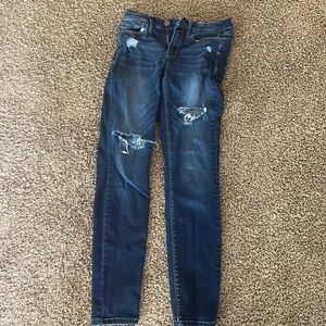 Dark blue low rise skinny size 5 has hole on the knee and thigh
